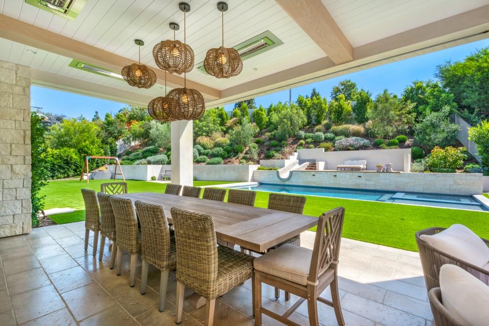 Área de refeições ao ar livre com mesa e cadeiras de jardim