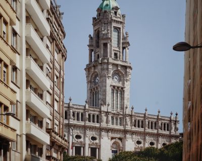 uma das principais avenidas do Porto, com edifícios elegantes e uma praça imponente.